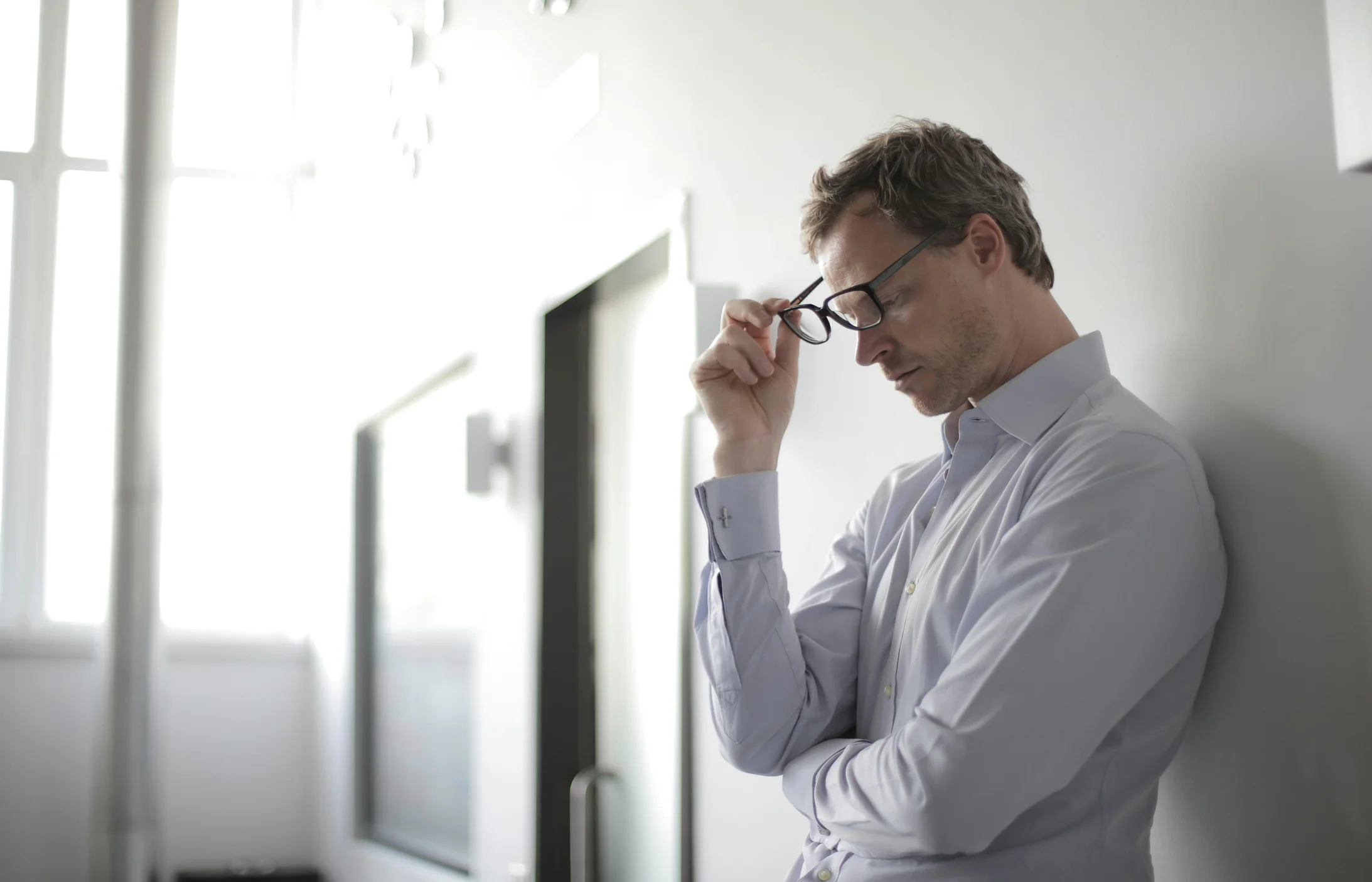 Photo of man holding black eyeglasses