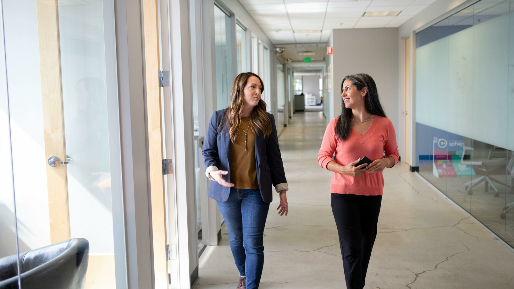 Women talking while walking on hallway