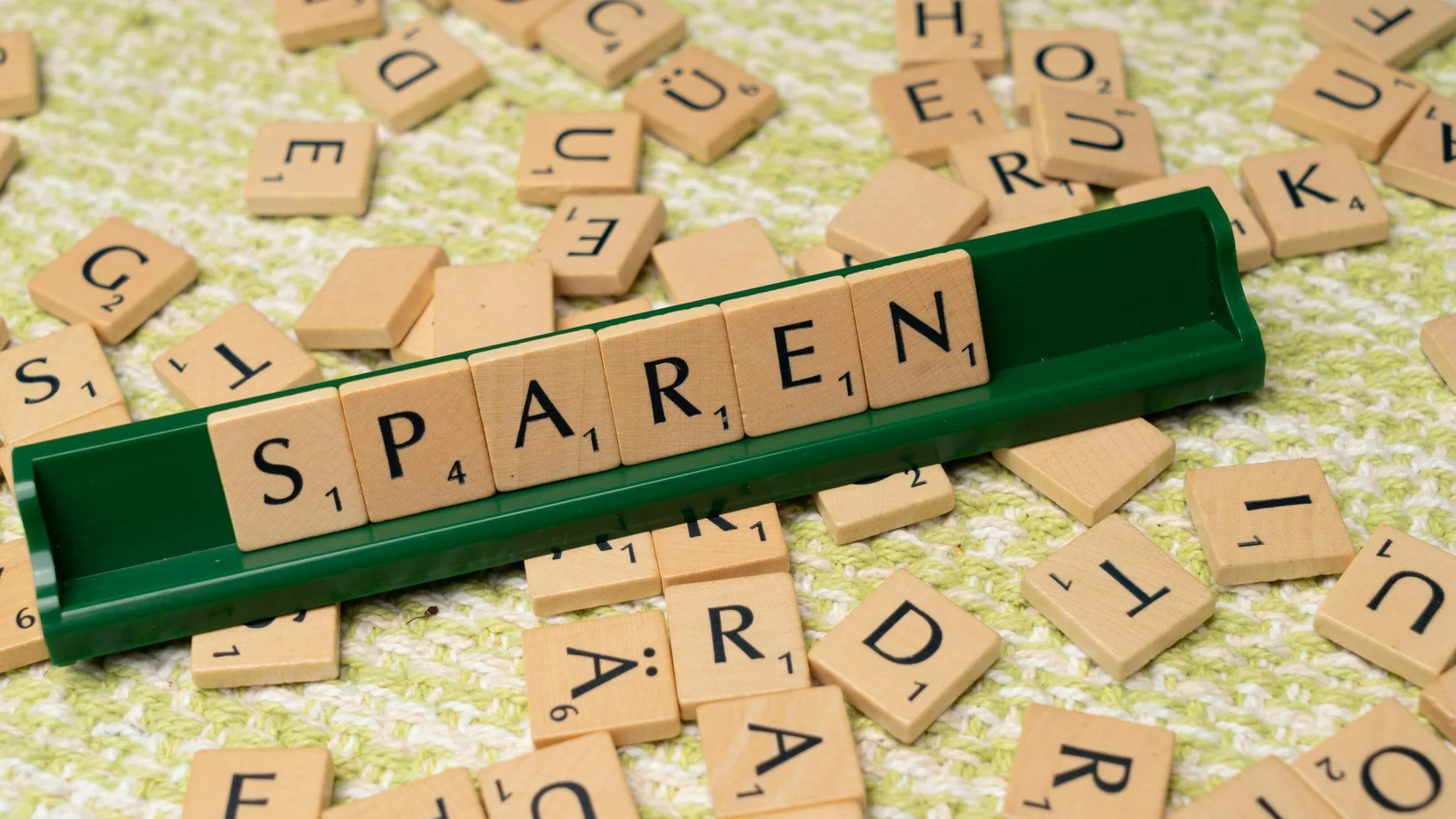 Scrabble tiles with the word sparen on them